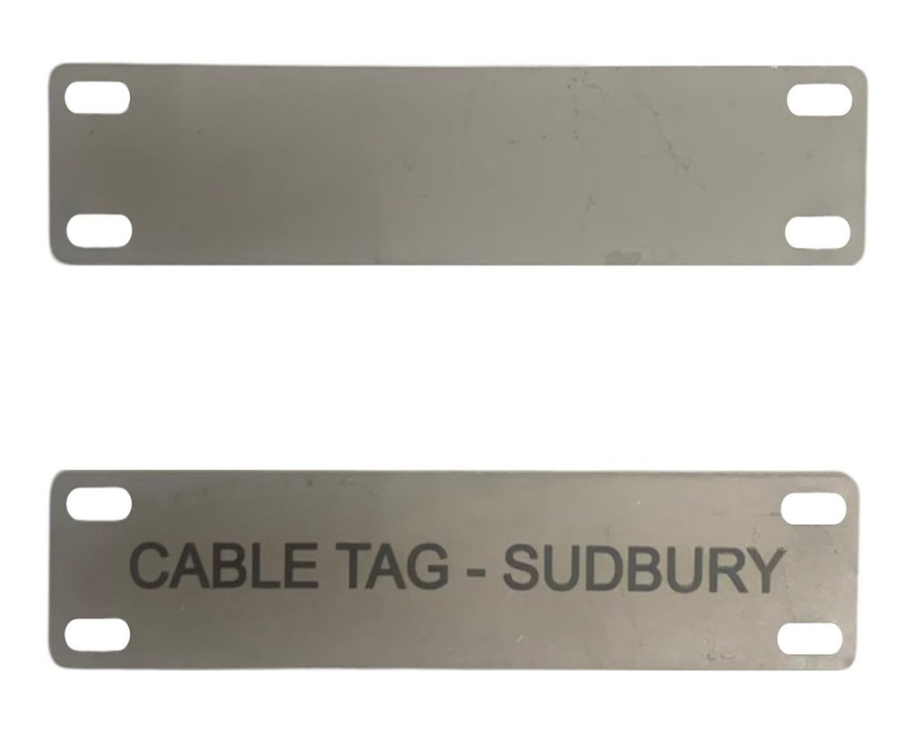 Two 304 stainless steel cable tags with four cable-tie slots: one blank and one laser-engraved with CABLE TAG - SUDBURY